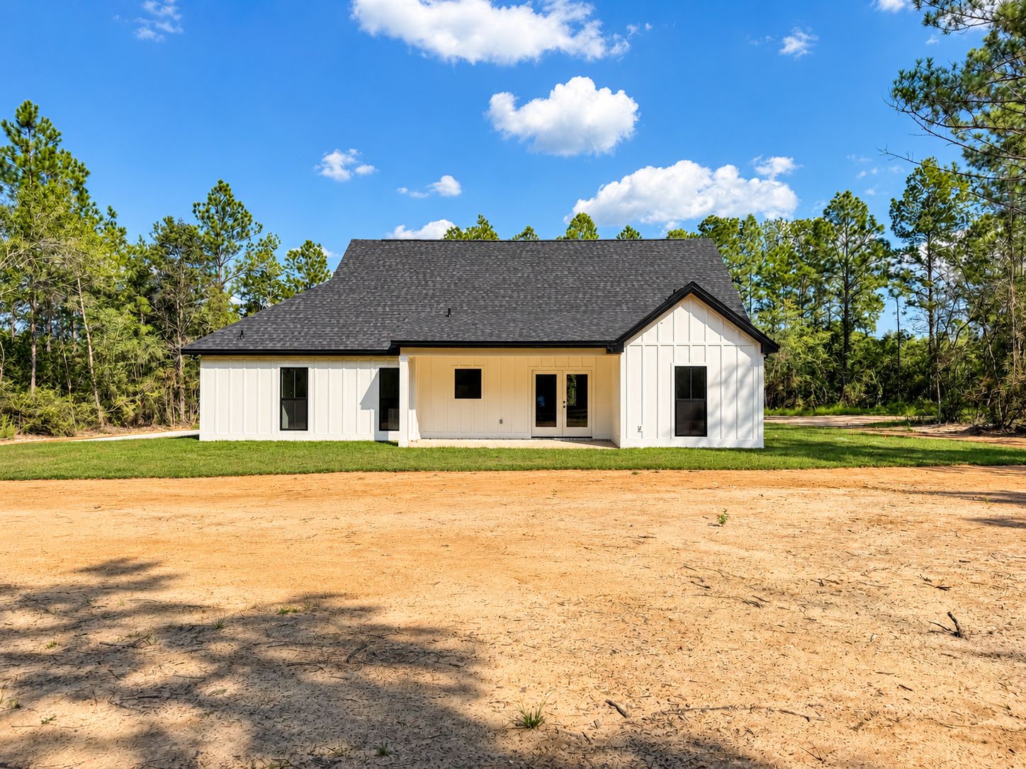 Rear exterior of the completed white home with a covered porch.