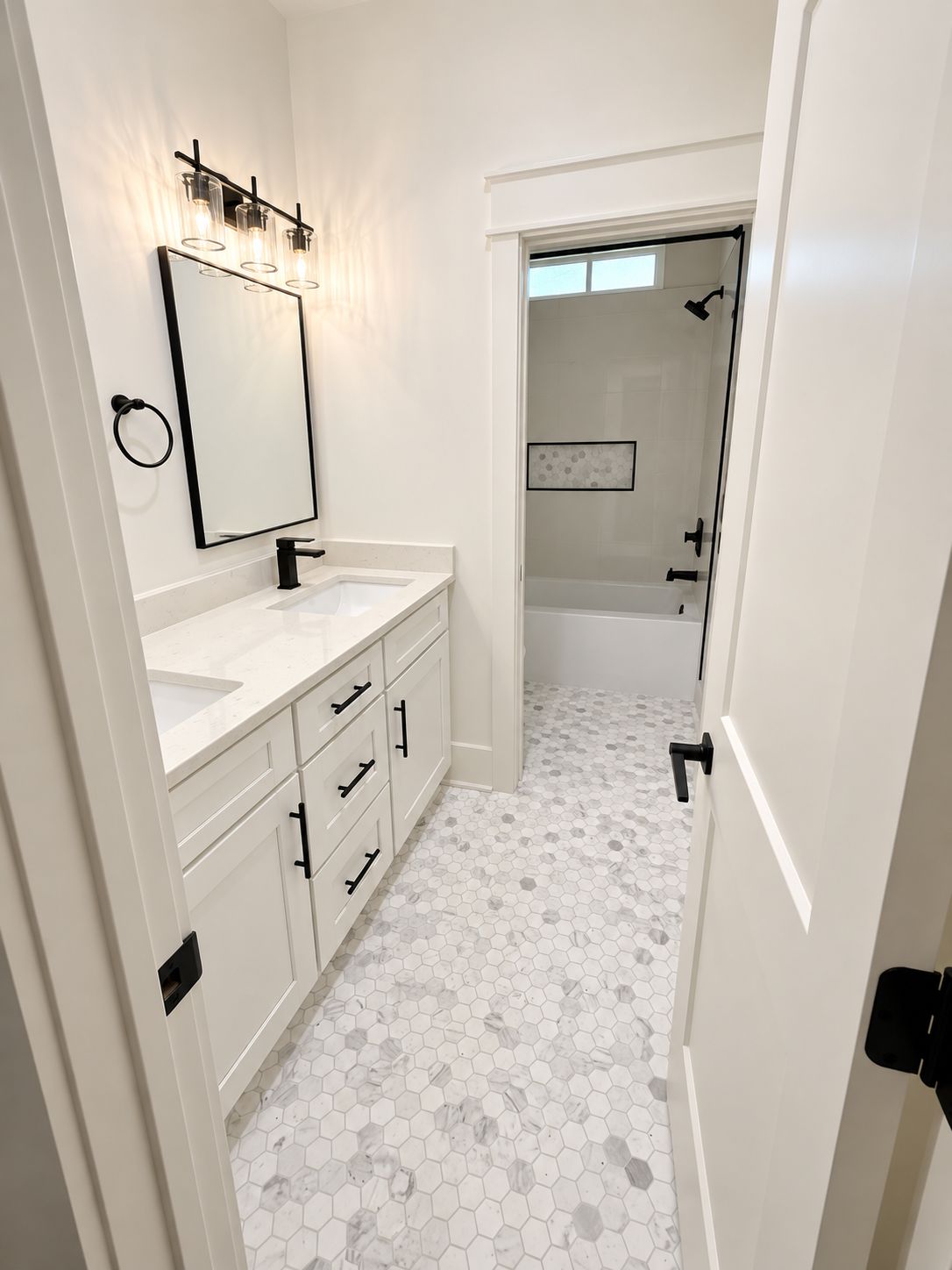Bathroom with a white vanity, black fixtures, and a glass shower enclosure.
