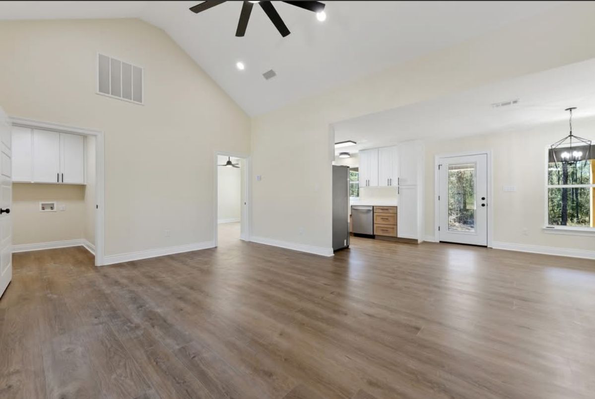 Open living area with a vaulted ceiling and a view toward the kitchen.