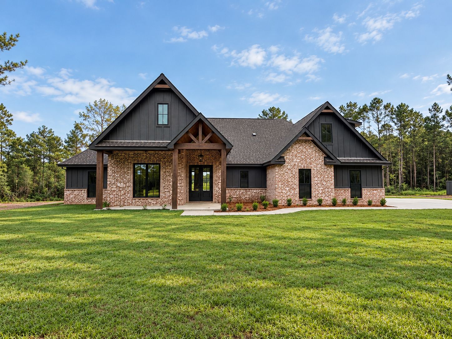 Front exterior of a completed brick home with dark siding, twin roof peaks, and timber porch details.